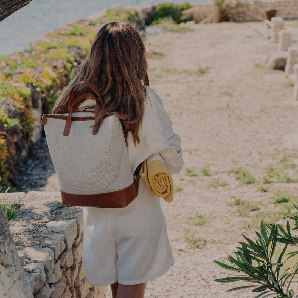 Canvas Rucksack in Caramel tragend auf dem Weg zum Strand