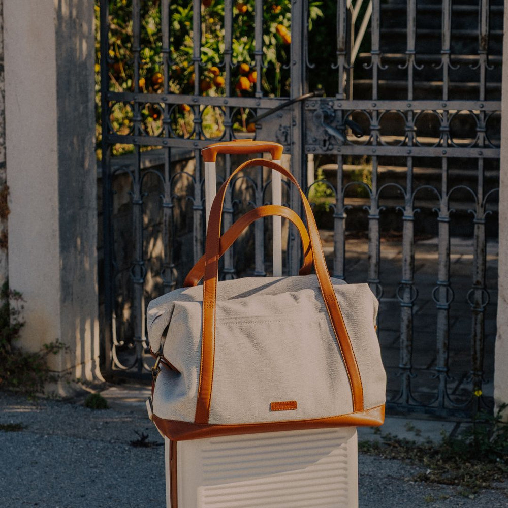 Canvas Weekender in Caramel auf einem Koffer